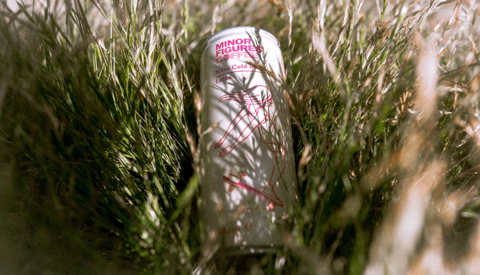 Nitro cold brew coffee can resting in sunlit grass