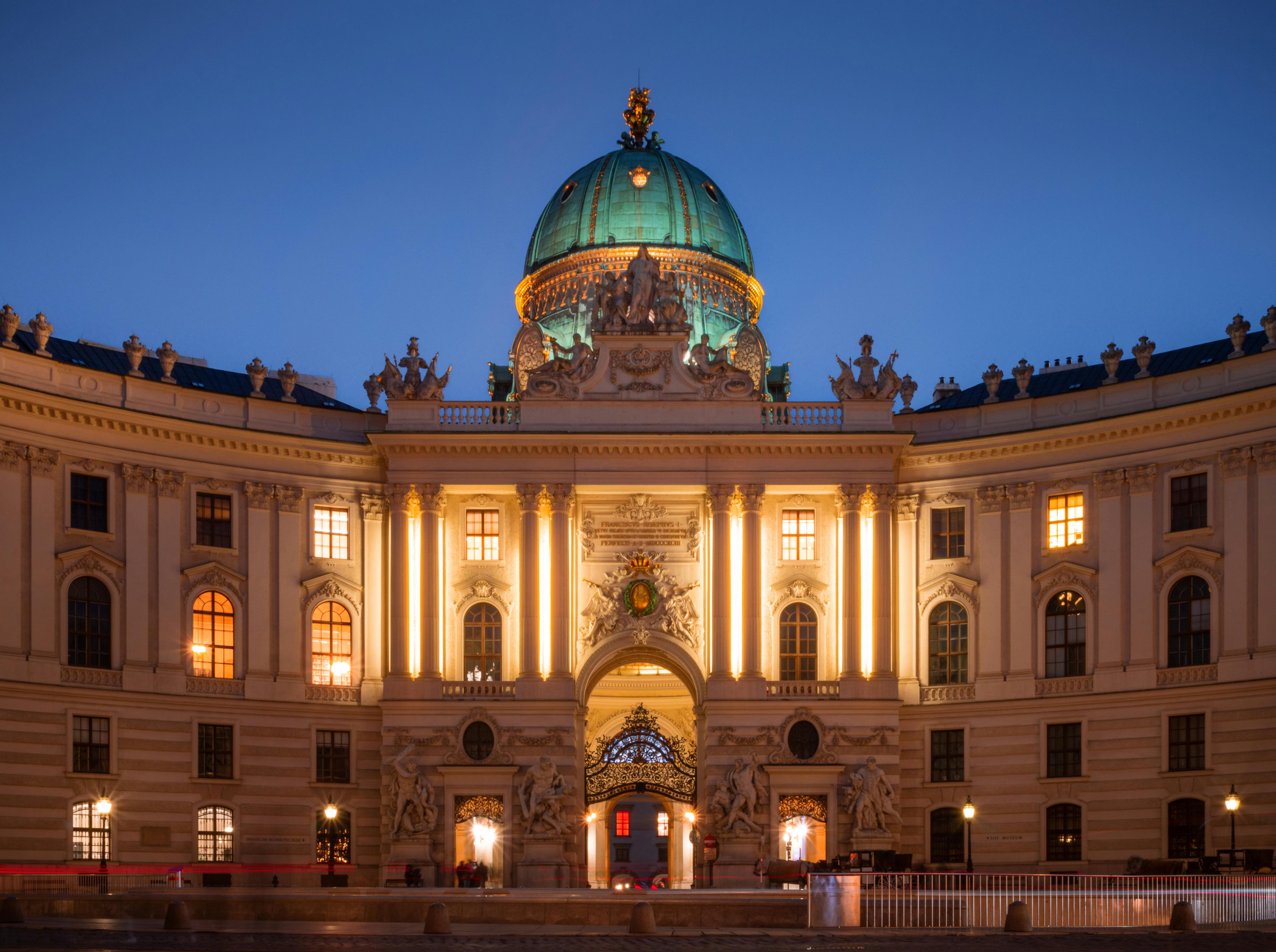 the building is lit up at night with a dome