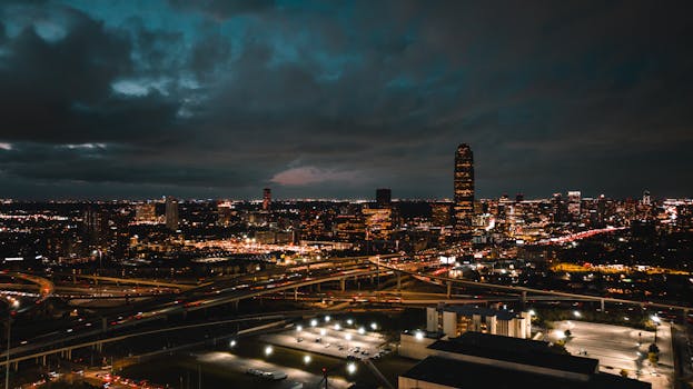 A breathtaking aerial shot of Houston's vibrant cityscape at night, featuring busy freeways and illuminated buildings.