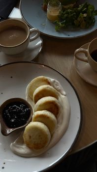 Delicious breakfast scene with coffee, pastries, and jam on a well-set table.