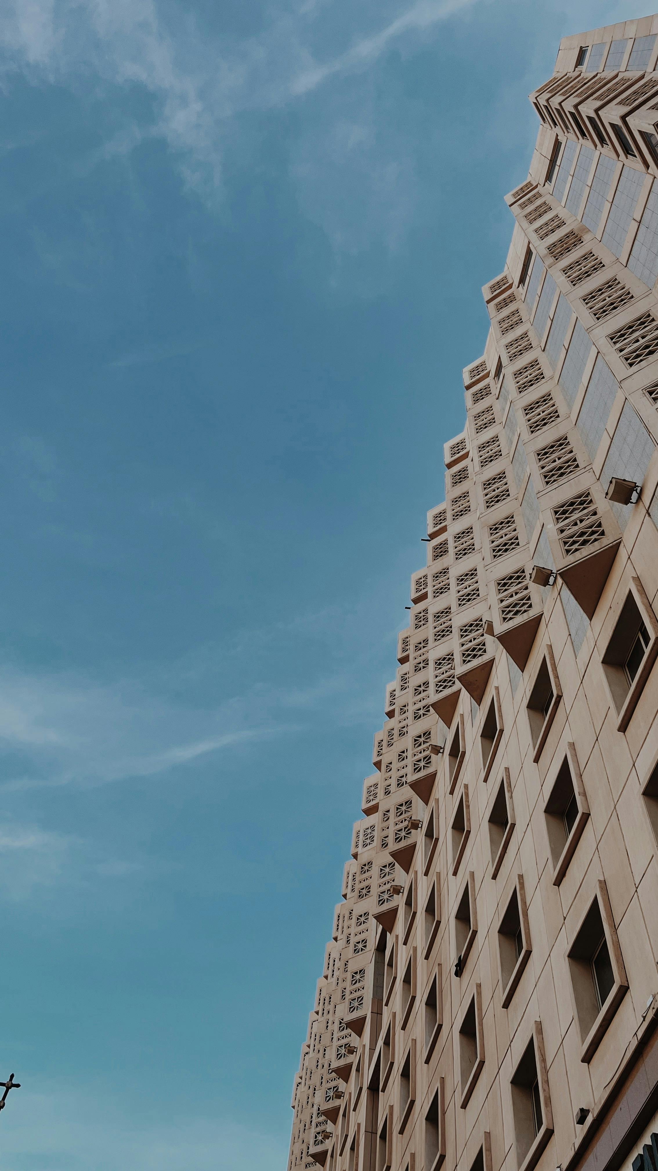 Elegant modern architecture with geometric facade against a clear blue sky.
