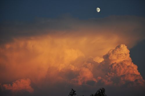 Free Captured at twilight, stunning sunset clouds with a visible moon overhead. Stock Photo