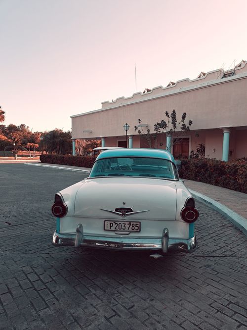 Free Rear view of a vintage car on a scenic street in Varadero, Cuba at twilight. Stock Photo
