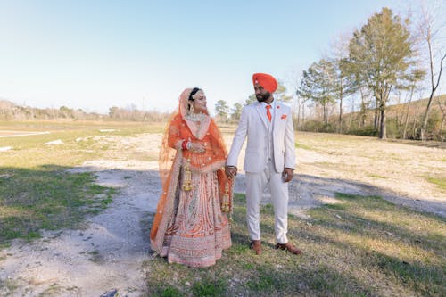 A Couple Holding Hands on a Field