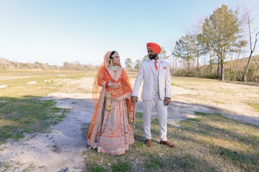 A couple in vibrant traditional Indian attire holding hands outdoors, embracing love and culture.