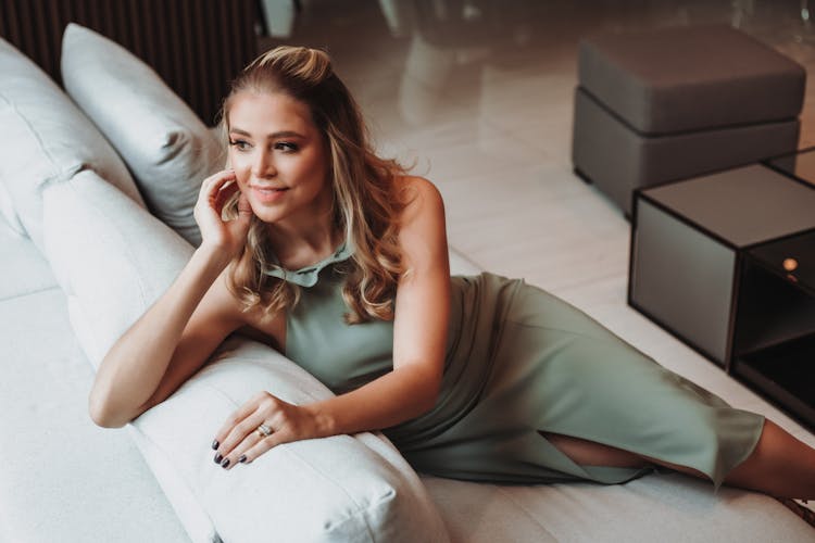 Woman In Dress Sitting On Couch