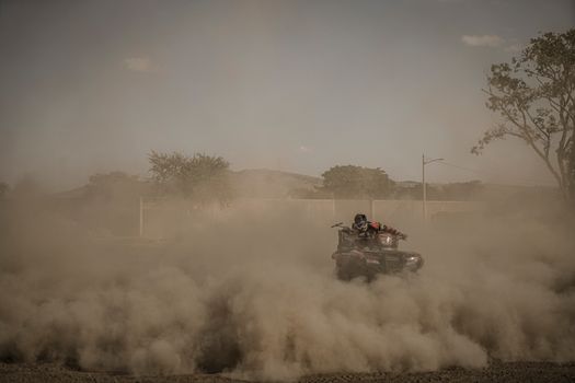 Man Riding on Quad Bike in the Dust