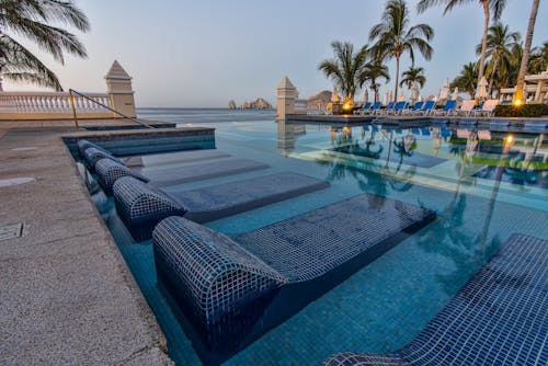 Blue Sun Loungers On Swimming Pool