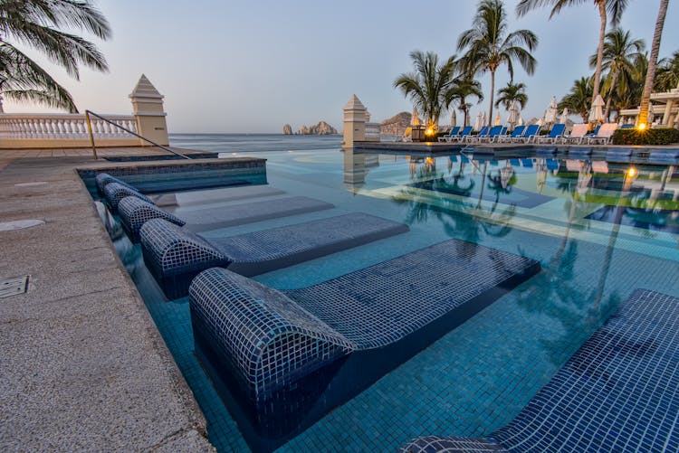 Blue Sun Loungers On Swimming Pool