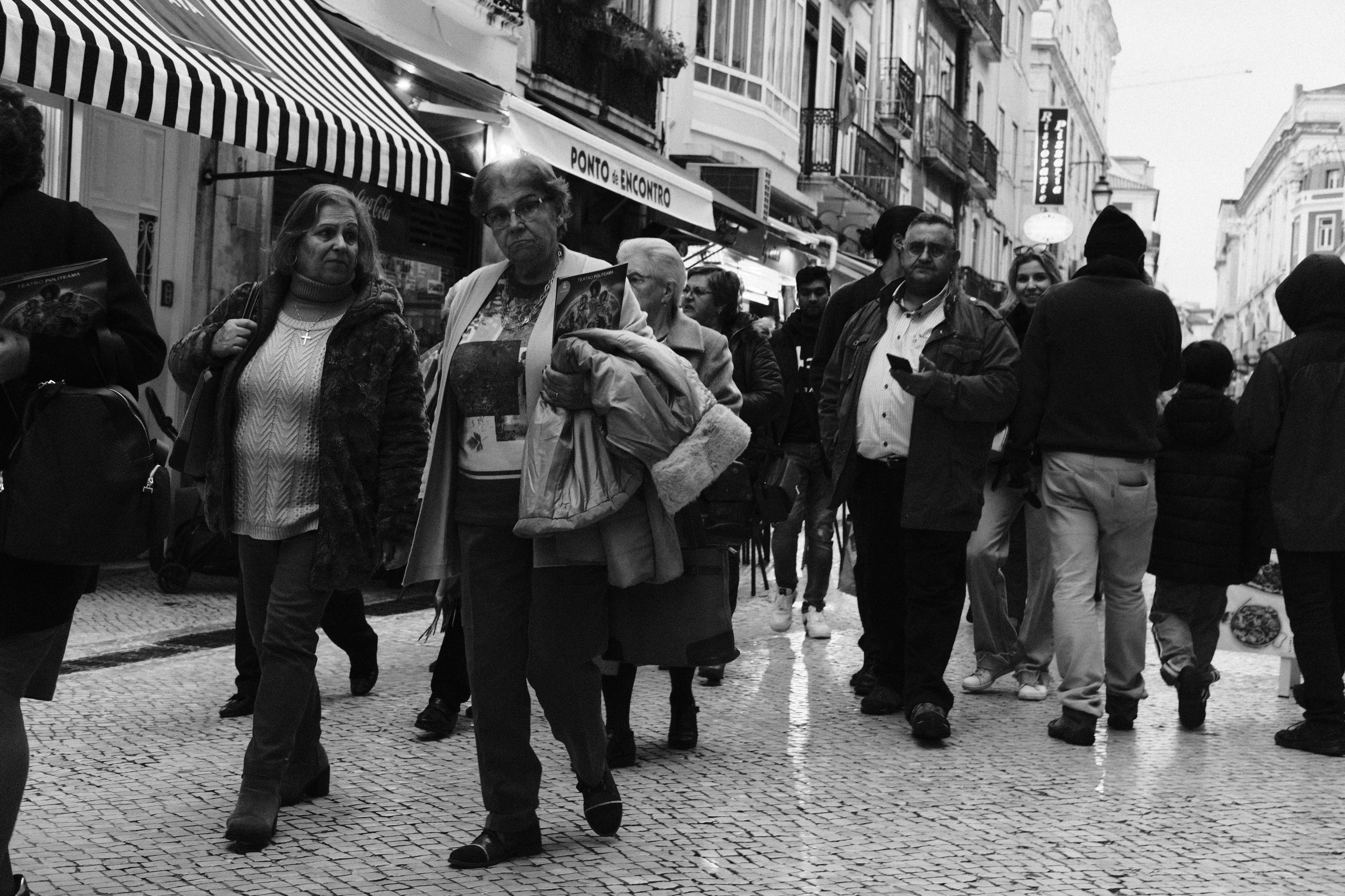 A pair of comfortable walking shoes on a historic cobblestone street in Lisbon, Portugal.