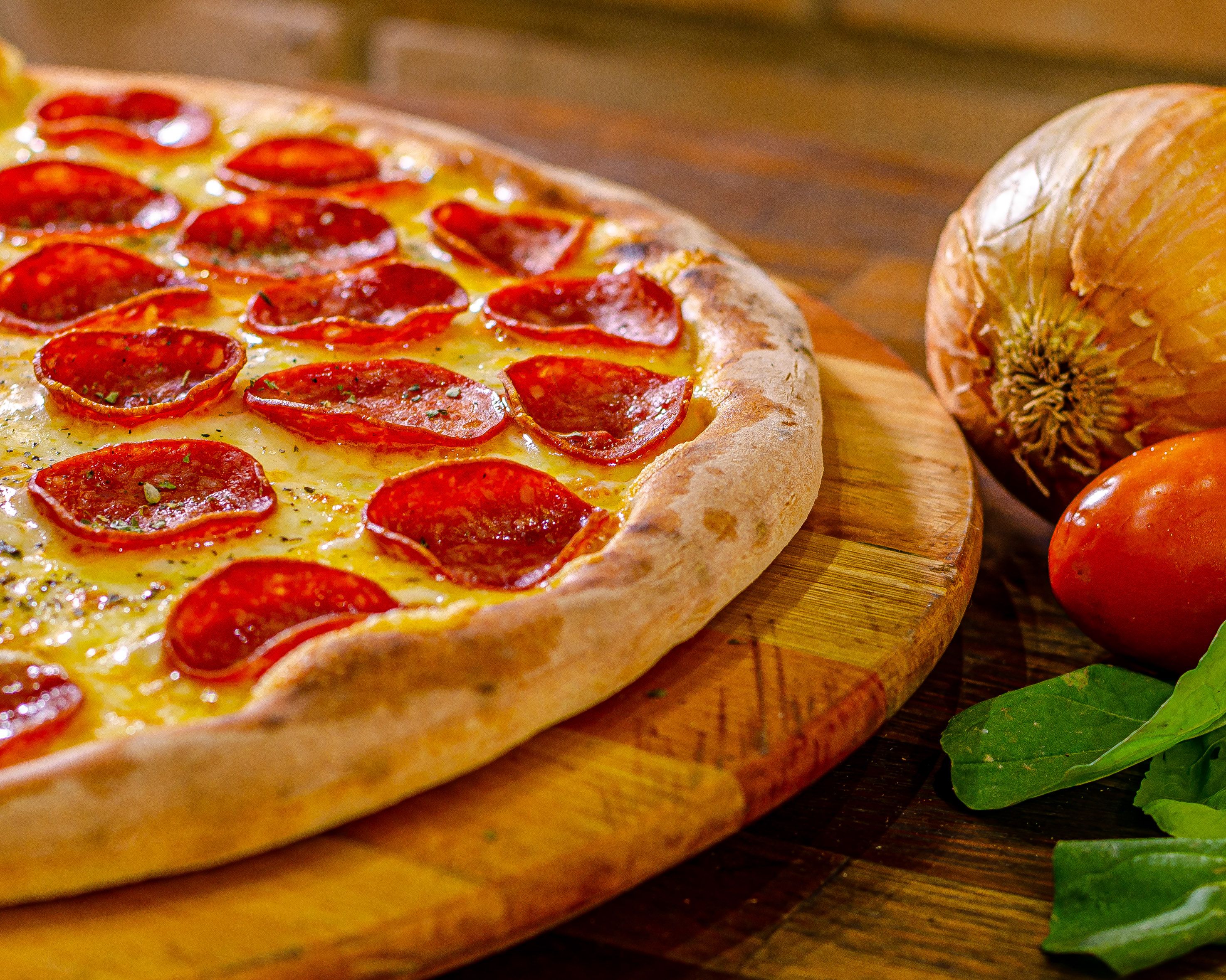 Fresh frozen pepperoni pizzas arranged on a kitchen counter before baking