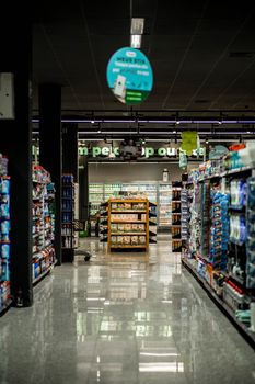 A well-lit grocery store aisle with stocked shelves, reflecting a serene shopping environment.