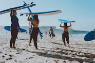 妇女带着冲浪板，在阳光明媚的海滩上享受一天的冲浪和娱乐