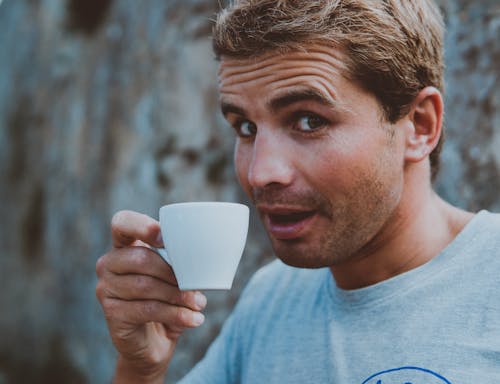 Selective Focus Photography of Man Holding Teacup