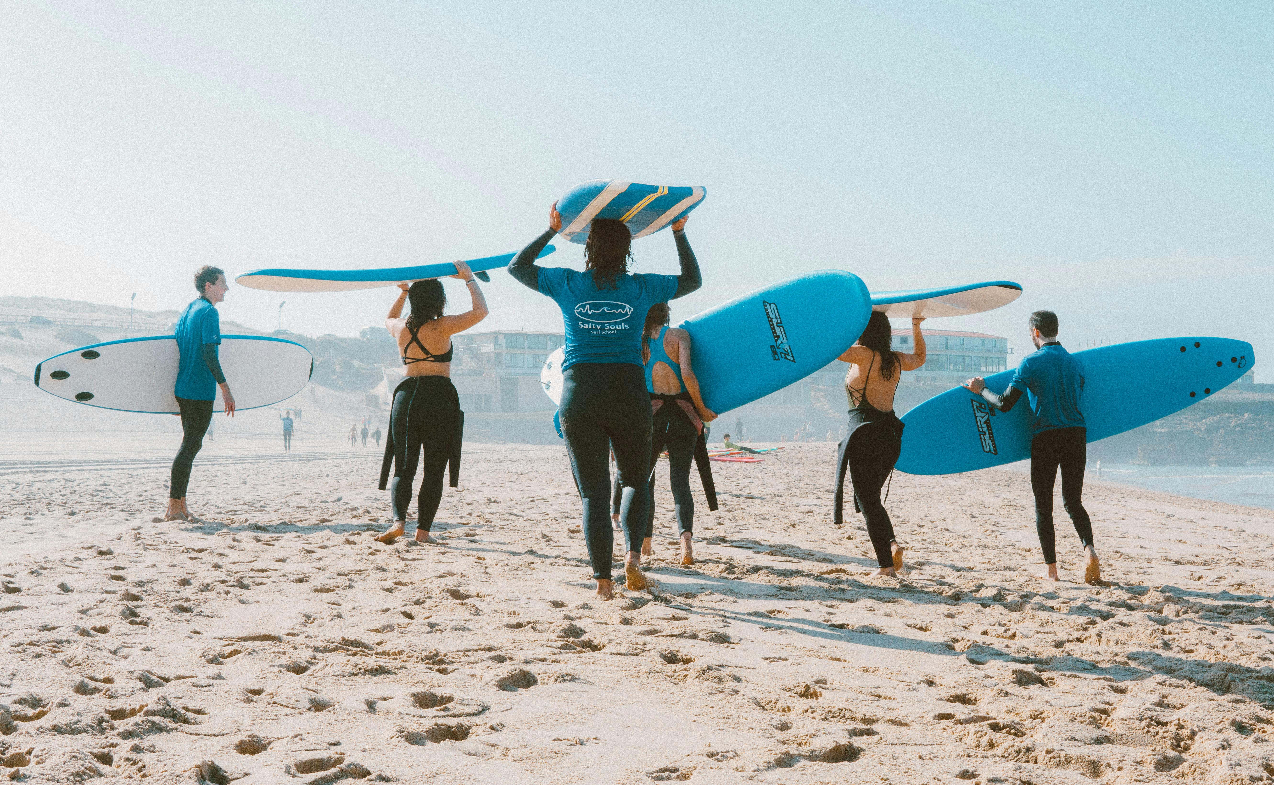 group of people carrying surfboards