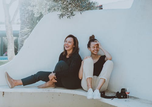 Twee Vrouwen Die Op Witte Bank Zitten