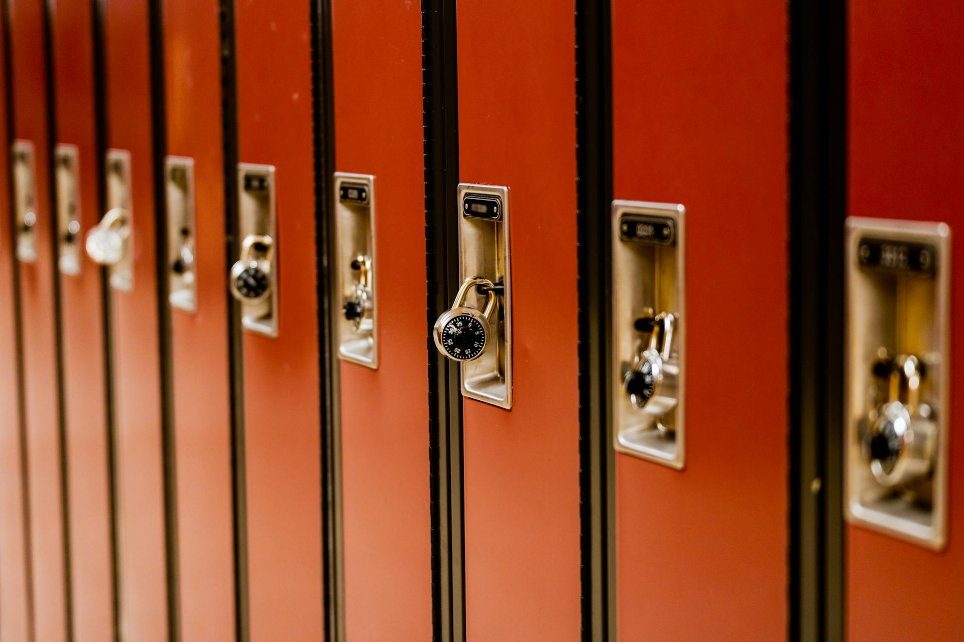 A line of brown school lockers with padlocks arranged indoors, providing secure storage.