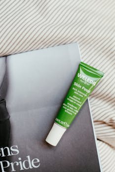 Top view of Weleda Skin Food tube on a magazine against a striped fabric background.