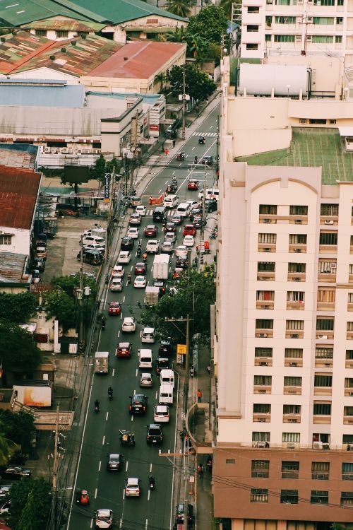 Free Busy city traffic from above with high-rise buildings lining the street. Stock Photo