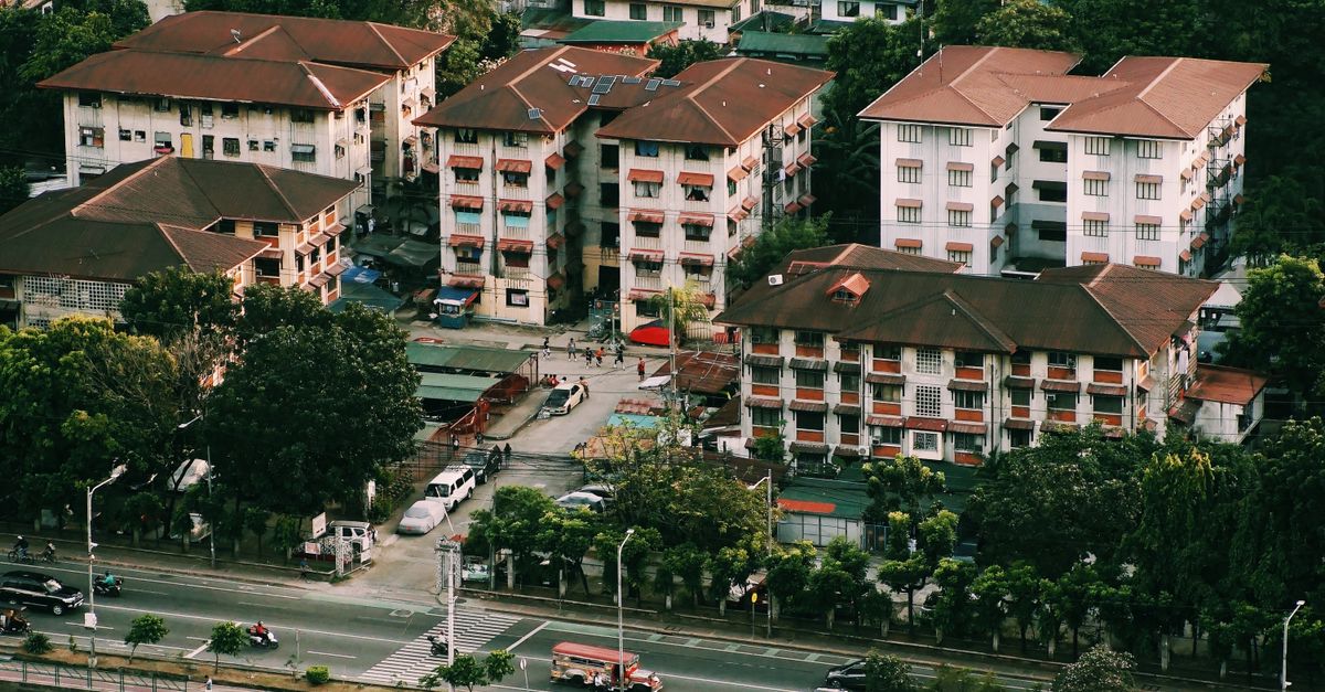 High angle view of residential buildings and streets lined with trees in a city setting.