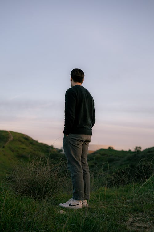 Man in Sweatshirt Standing on Meadow