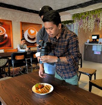 Man photographing food inside a café in Davao City, Philippines.