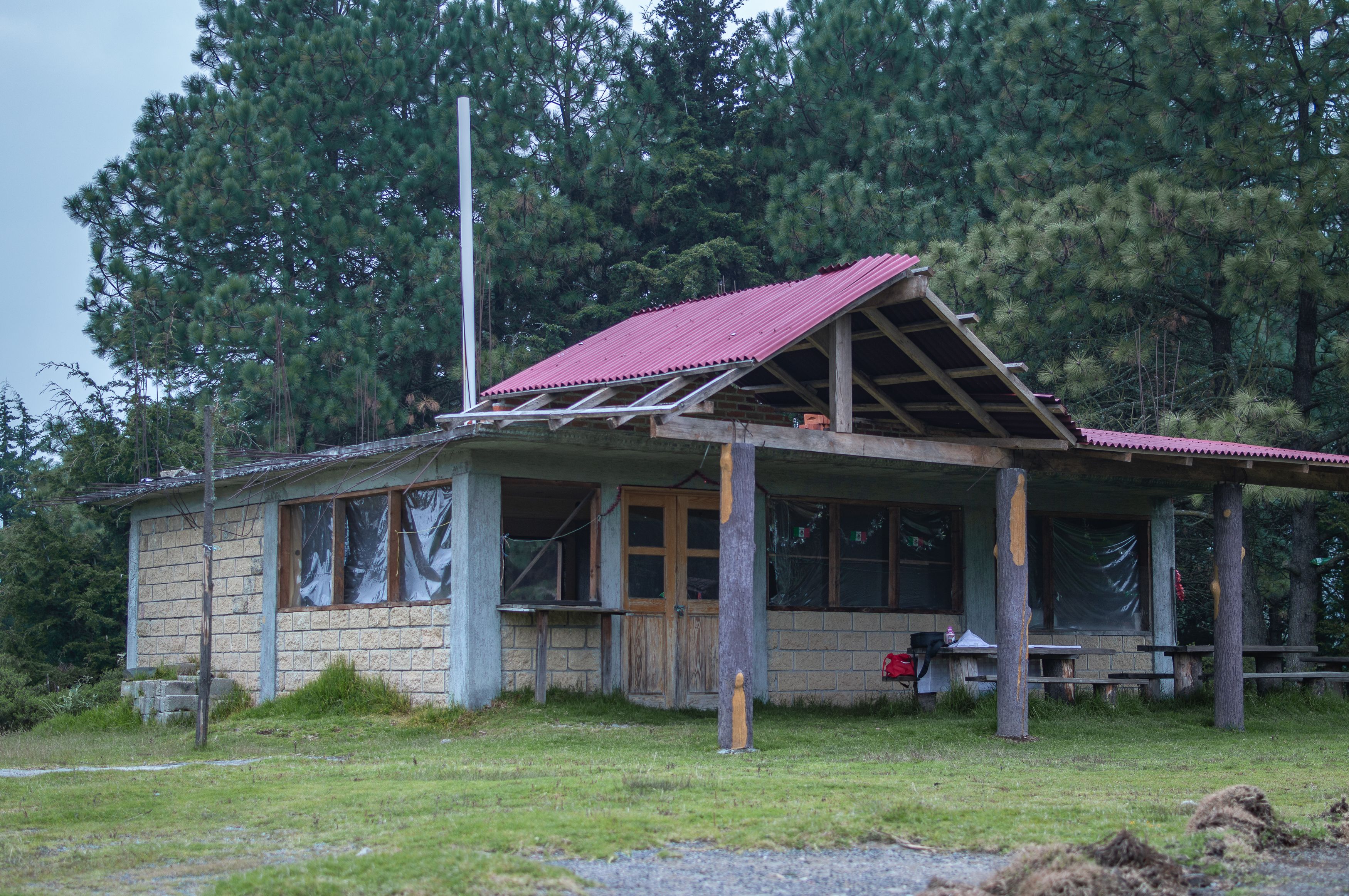 Wooden cabaña with a porch among pine trees in the high Lenca mountains