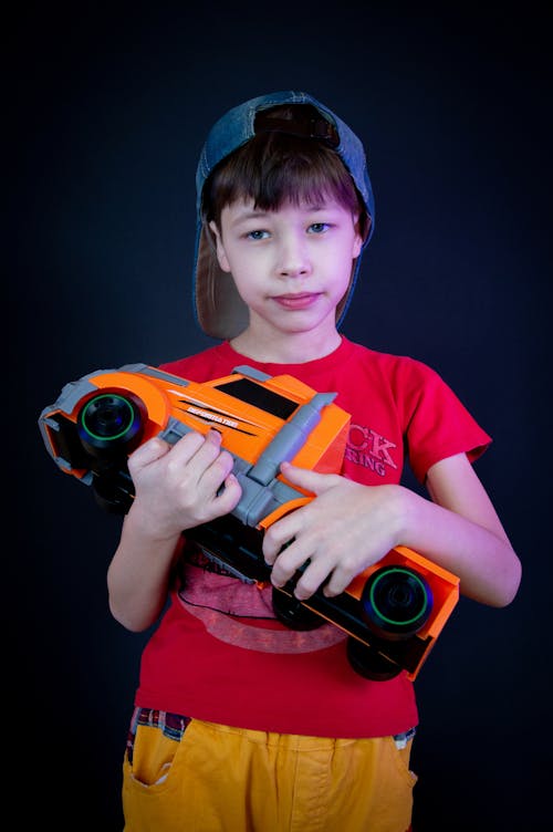 Безкоштовне стокове фото на тему «вантажівка іграшка, вертикальні постріл, дитина»
