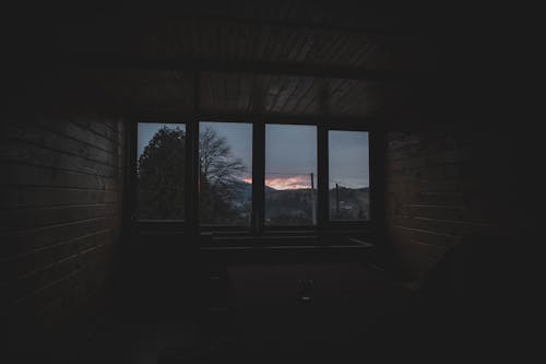 Room in Wooden House in Darkness at Sunset