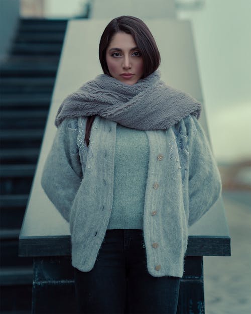 Woman in Scarf and Sweater Standing by Stairs Wall