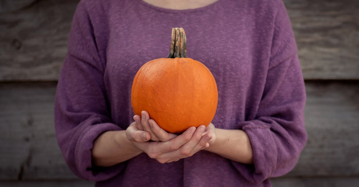 Photo of Woman Carrying Pumpkin on Both Hands