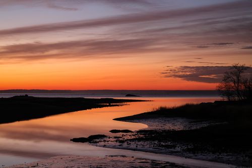 Free Stunning sunset reflection over a tranquil rural lake, capturing nature's serene beauty. Stock Photo