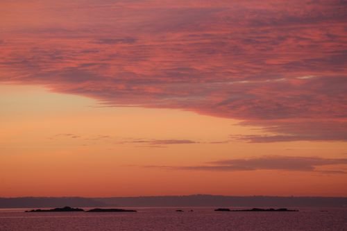 Free Tranquil sunset view with vibrant orange and pink sky over Stamford Harbor. Stock Photo