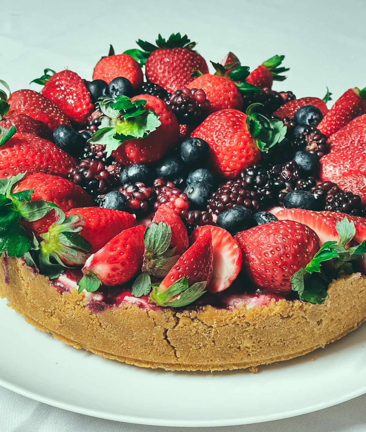Cake topped with fresh strawberries and mixed berries instead of fondant