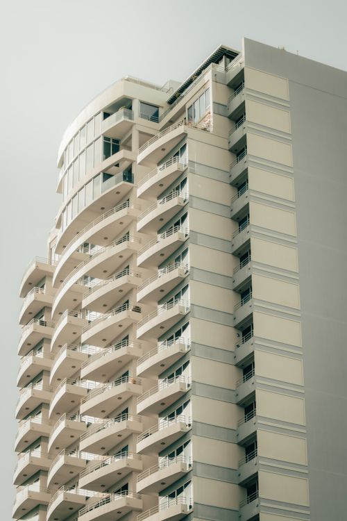 Free Low angle view of a modern high-rise building with balconies in a cloudy setting. Stock Photo