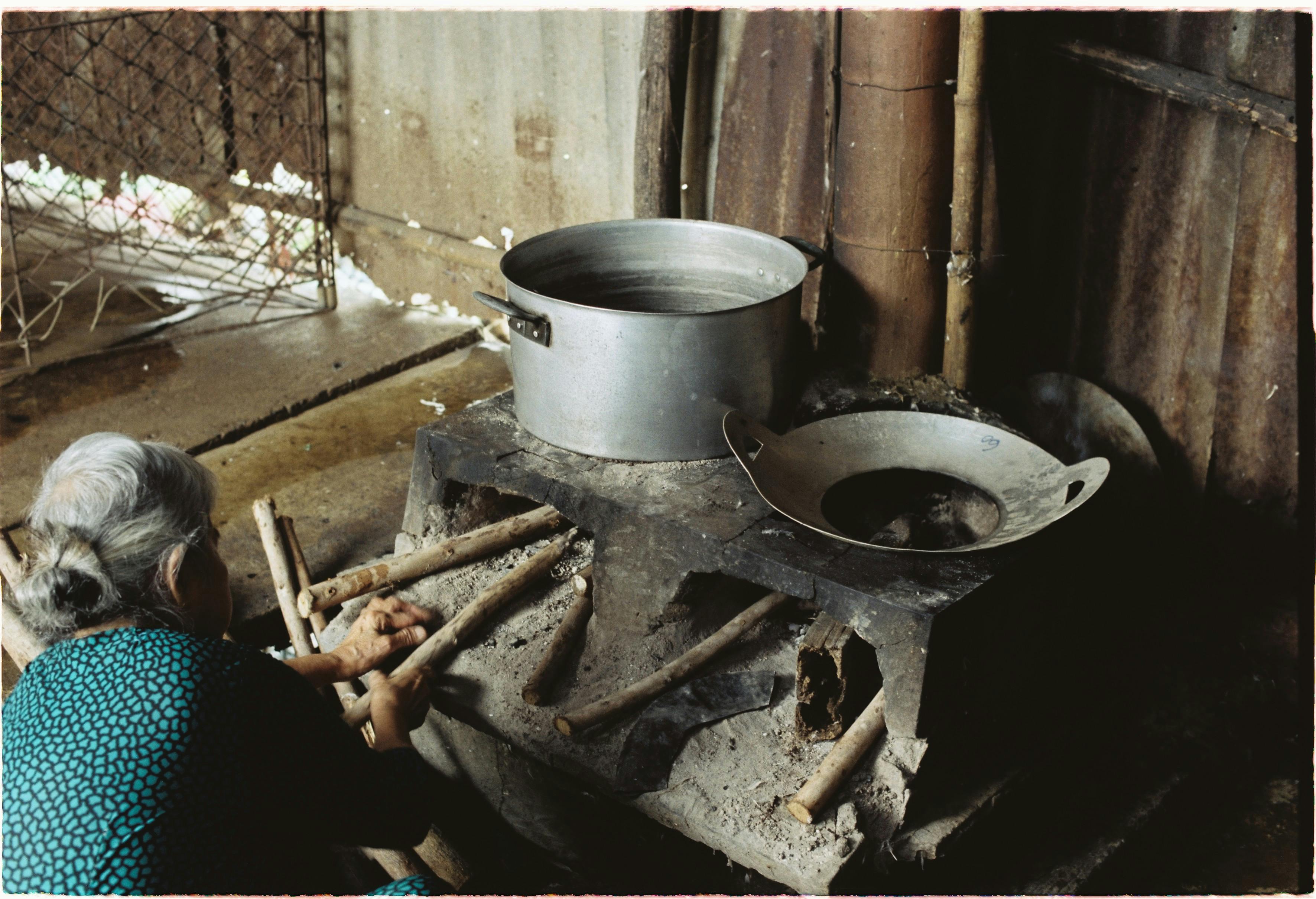 Elderly Woman Cooking on Old Stove in Village · Free Stock Photo