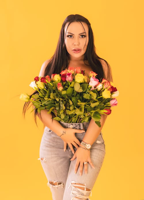 Sexy Woman with Flowers on Naked Chest Posing in Studio