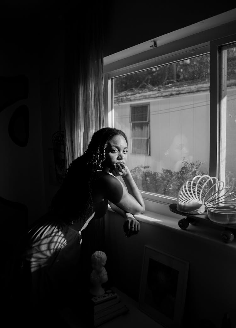 Woman Standing Near House Window