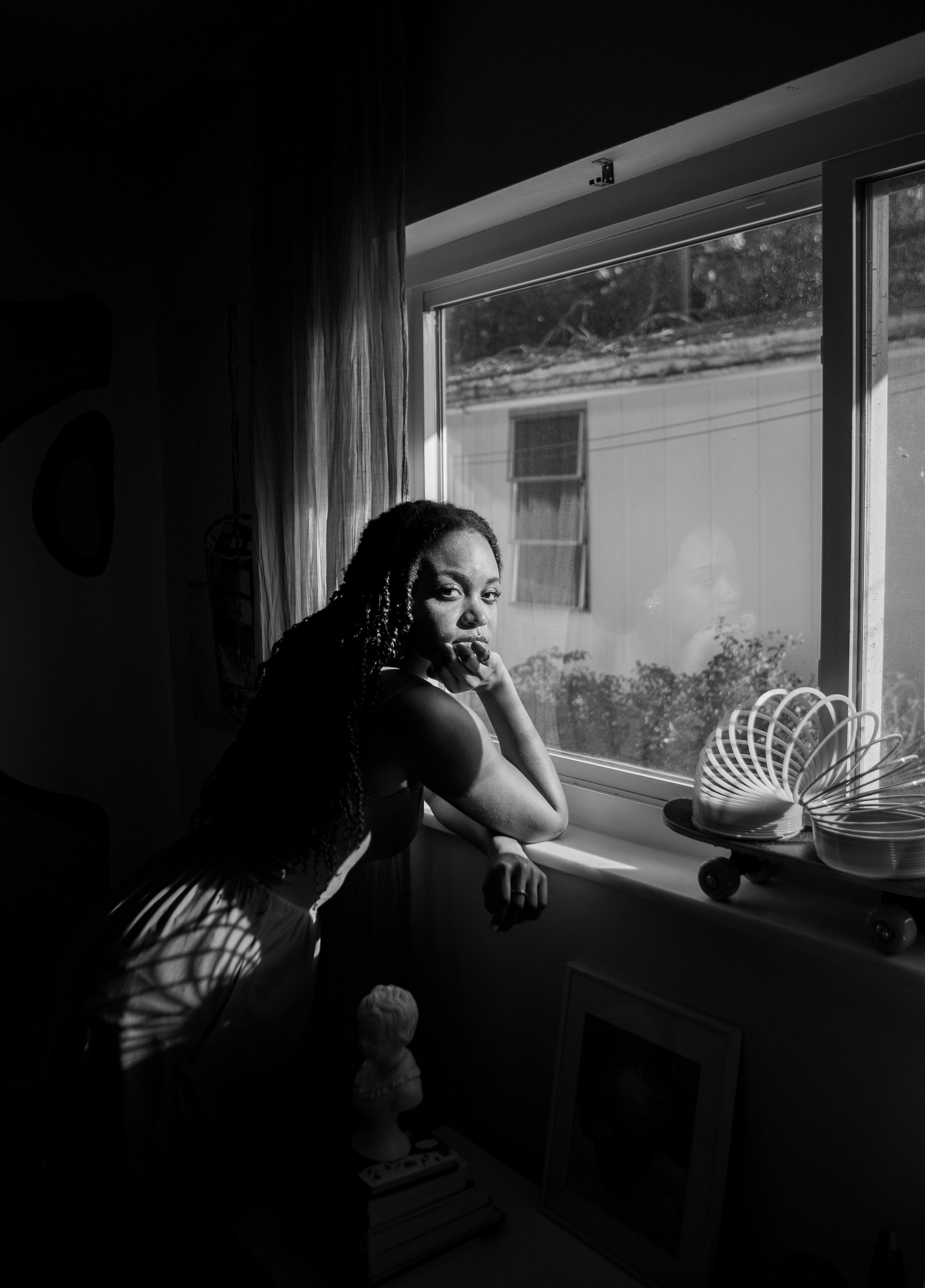 Woman in White Tank Top and Blue Denim Jeans Sitting on Windowsill ...