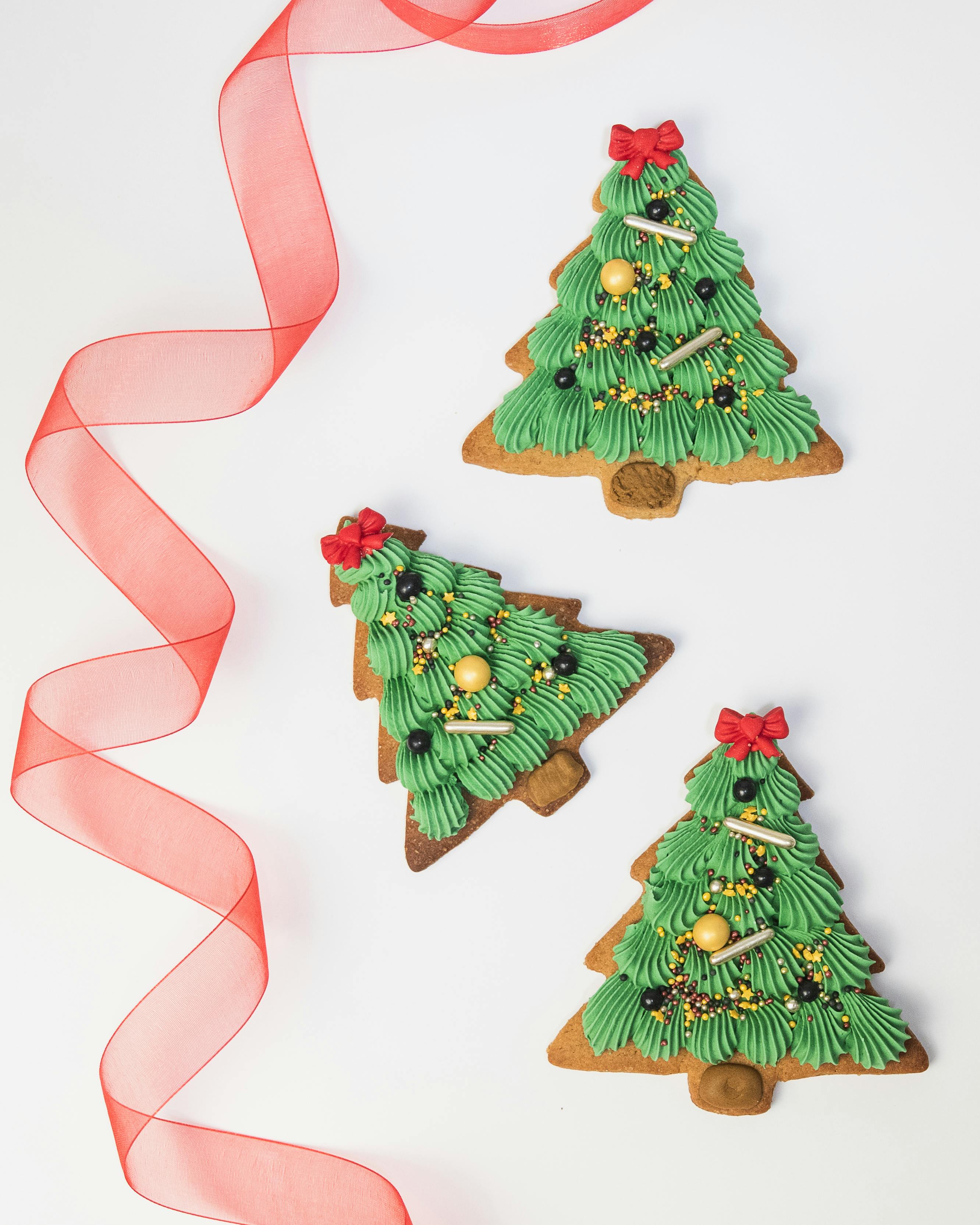 Decorative Christmas tree cookies with festive ribbons, perfect for holiday celebrations.