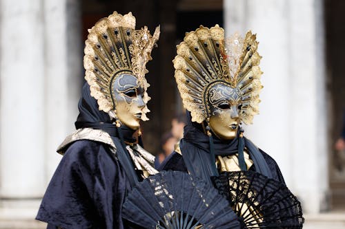 People Posing in Costumes with Golden Masks