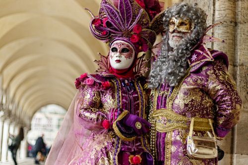 Free Elegant portrait of two adults in Venetian carnival costumes with ornate masks and traditional garments. Stock Photo