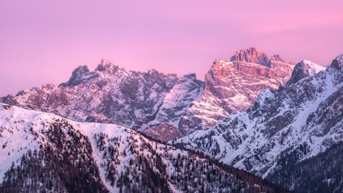Free A breathtaking view of the snow-covered Dolomites under a pink sunset sky, showcasing nature's beauty. Stock Photo