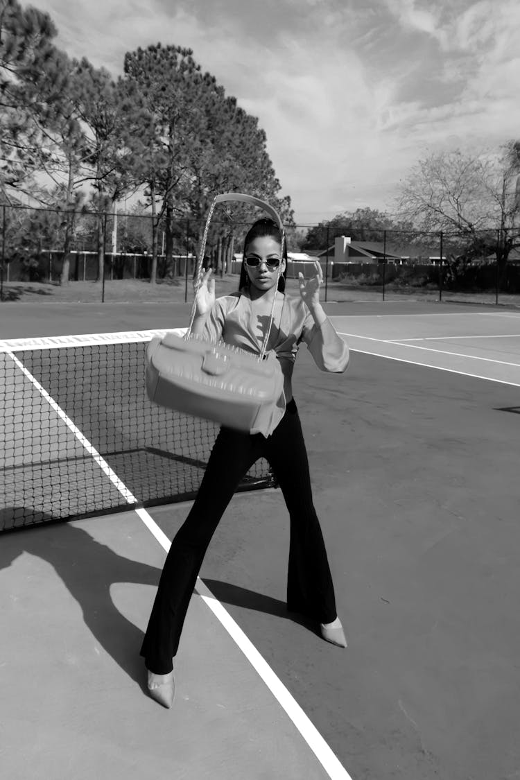 Woman Throwing Bag On Tennis Court