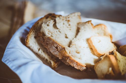 Free Close-up of freshly sliced rustic bread in a basket, showcasing a homemade feel and texture. Stock Photo