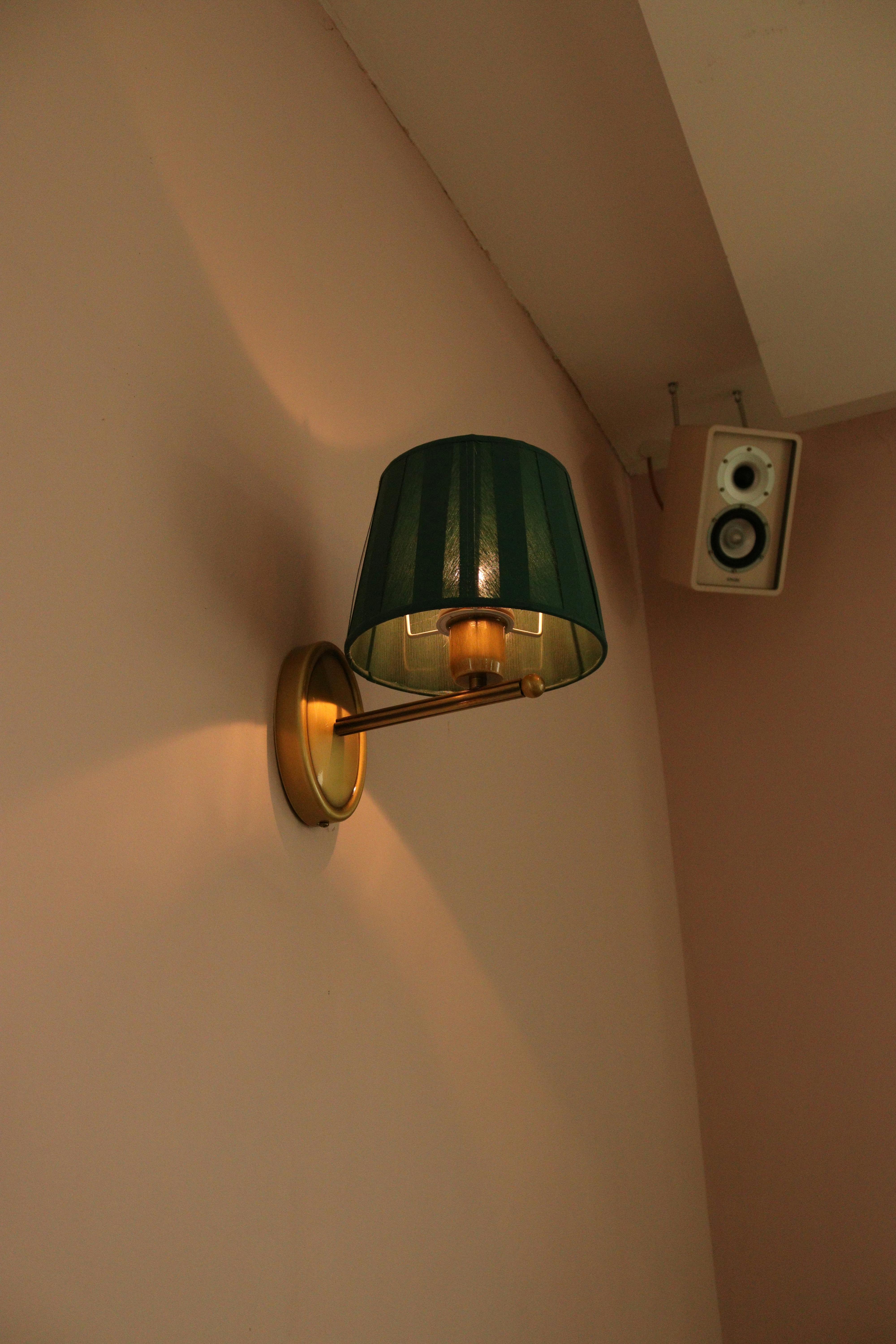 Free Stylish wall lamp with green shade and speaker in modern indoor setting. Ideal for design inspiration. Stock Photo