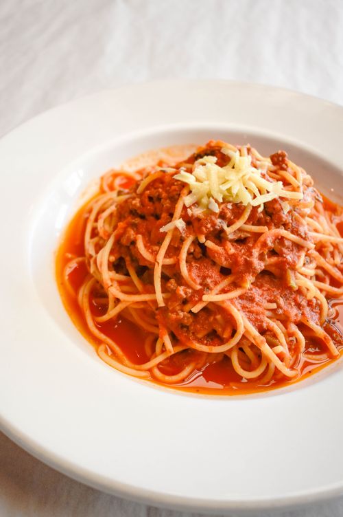 Free Mouth-watering spaghetti bolognese topped with cheese, perfect for dinner. Stock Photo