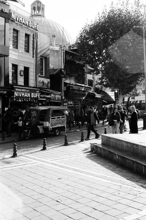 Black and White Photo of People Walking on a Street 