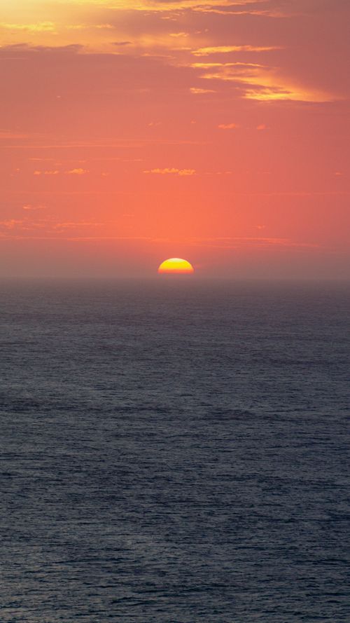 Free Peaceful ocean view with a vibrant sunset, perfect for a calming backdrop. Stock Photo