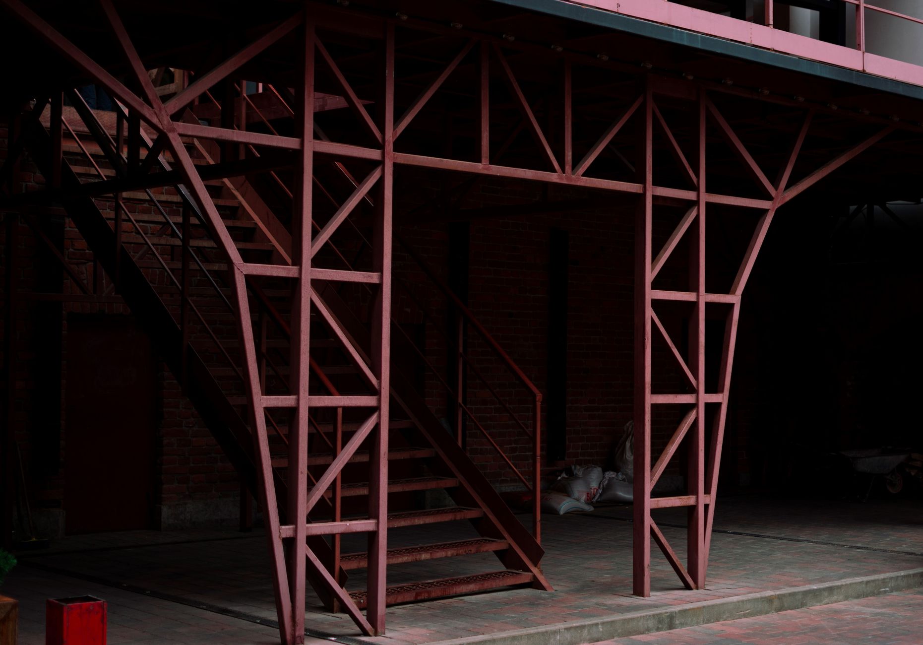 Close-up of a red metal staircase in a modern industrial setting.